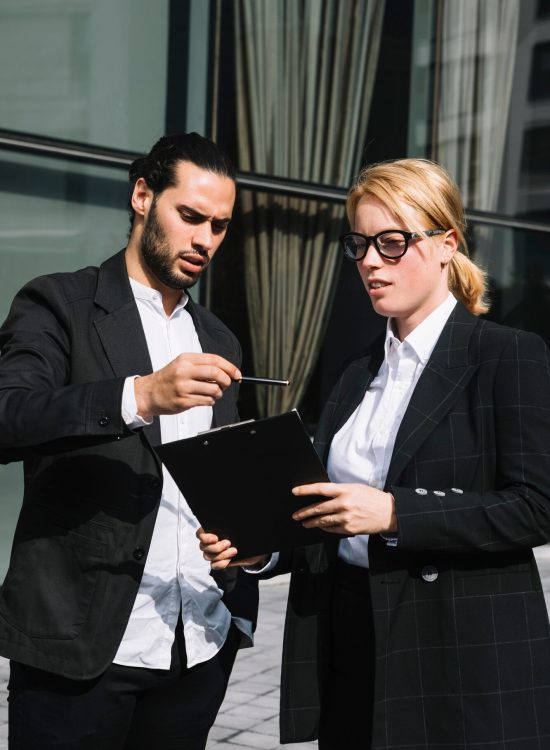 two-business-people-standing-outside-office-discussing-about-work_23-2147972780